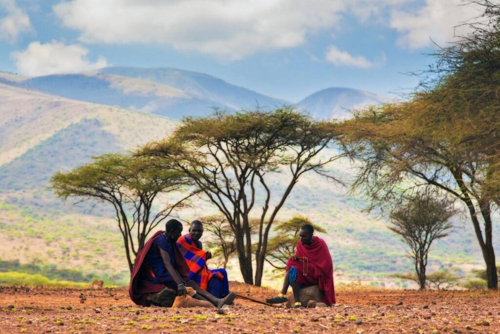 Maasai community members seen from a distance in their natural habitat during a cultural tour in Tanzania