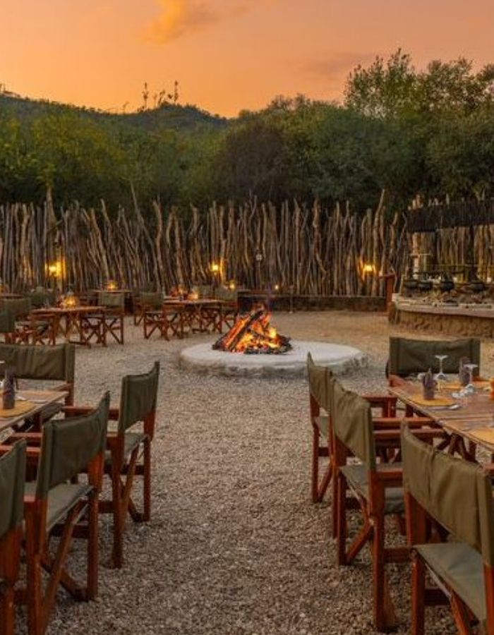 Guests enjoying a traditional African Boma experience with a fire pit, storytelling, and local cuisine