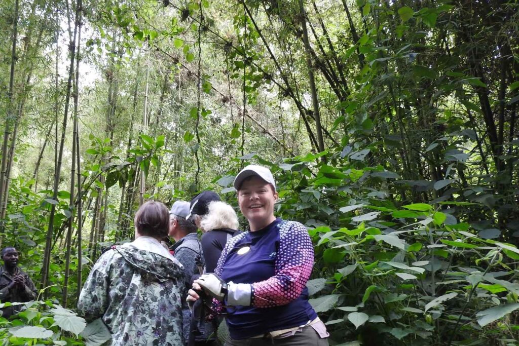 Travelers trekking through Rwanda’s lush forest to see mountain gorillas with Extraordinary Tours.