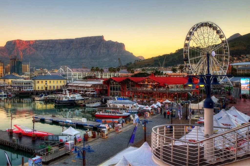 Scenic view of Cape Town Waterfront with boats, shops, and Table Mountain in the background